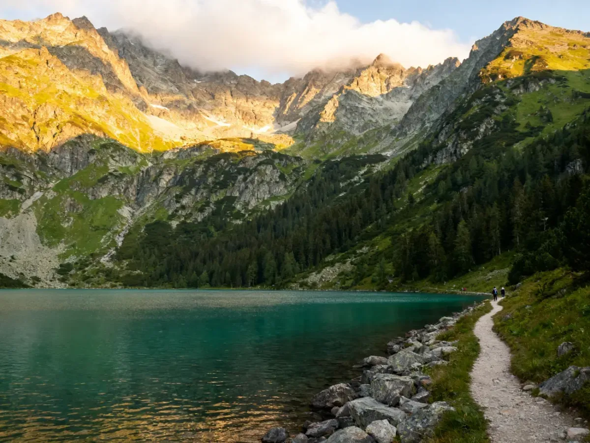 Morskie Oko o poranku, spokojne turkusowe wody otoczone szczytami Tatr i szlakiem dla pieszych