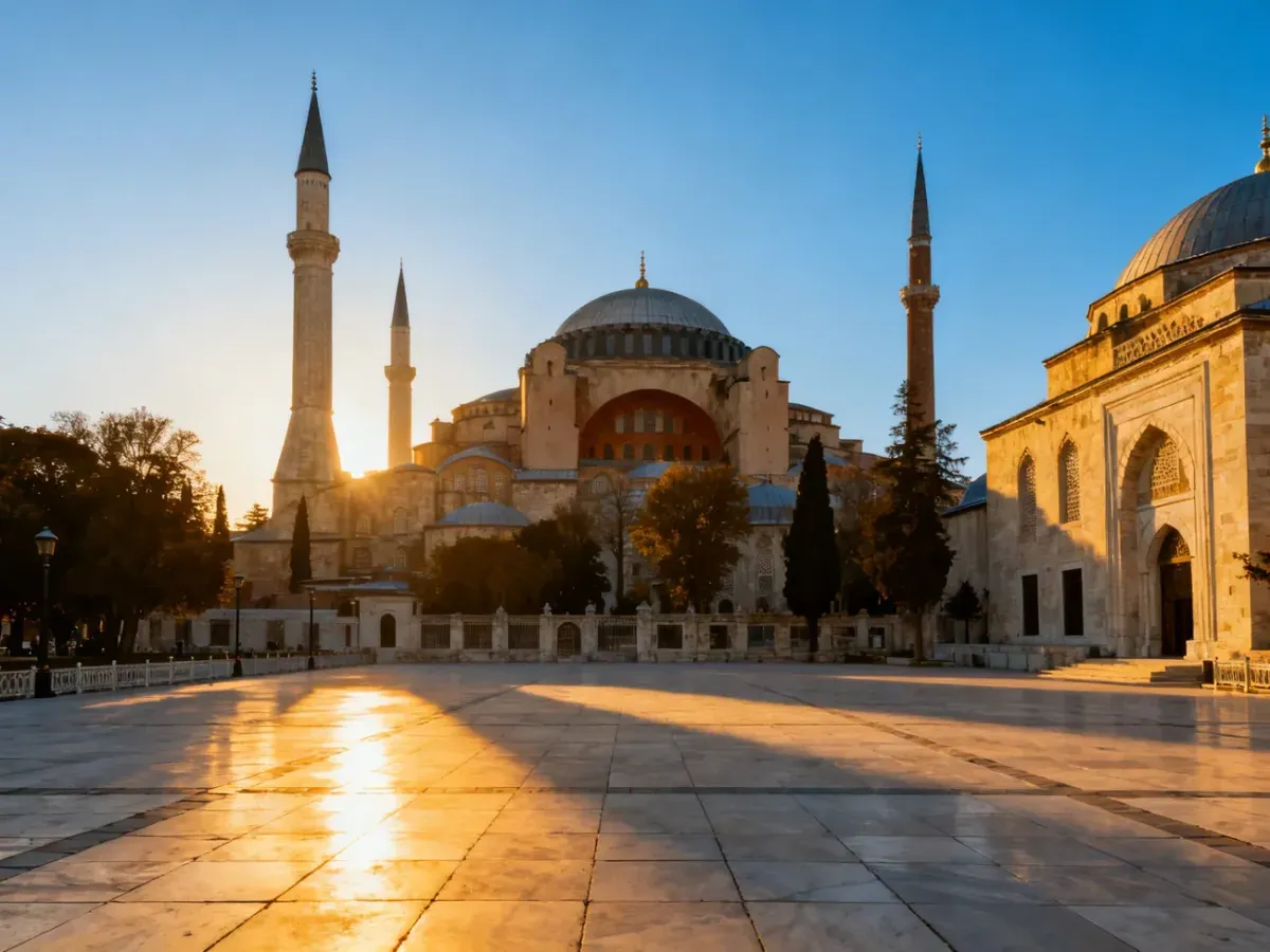 Majestatyczna sylwetka meczetu Hagia Sophia o zachodzie słońca z widoczną kopułą i minaretami na tle błękitnego nieba.