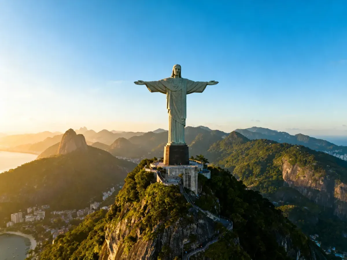 Pomnik Chrystusa Odkupiciela na szczycie góry Corcovado w Rio de Janeiro w promieniach zachodzącego słońca.